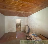 The interior of a family house with a wooden ceiling and tiles.