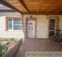 A family house in Palárikovo with a covered terrace, white doors, and bicycles.