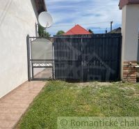 The courtyard of a family house in Palárikovo with a gate and a satellite dish.