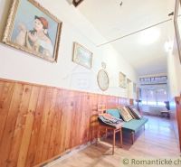 Hallway of a family house with wooden paneling, decorations, and flooring with a wooden design.