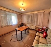 Living room with carpet decor, vintage furniture, and subtle lighting in a family house.