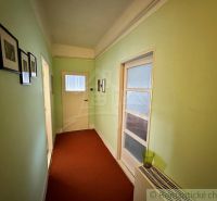 A hallway in a family house with painted walls and pictures on the walls.