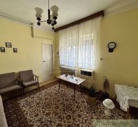 A living room in a family house with a carpet and curtains. Retro furniture complements the cozy atmosphere.