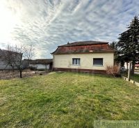 A family house in Kolárovo surrounded by a lawn, trees, and a fence.