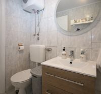 Bathroom in a Holiday Apartment with a sink, mirror, and toilet.