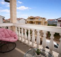 Balcony of a holiday apartment in Vodice, comfortable chair with a view of the buildings.