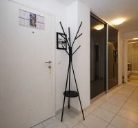 A hallway with a coat rack and a mirrored wardrobe in a holiday apartment.