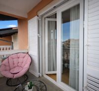The balcony of a holiday apartment with a comfortable chair and a view of Vodice.