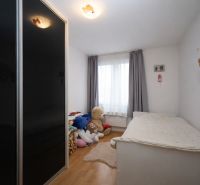 Children's room in a recreational apartment with toys, a bed, and a floor with a wooden decor.