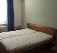Bedroom in a 2-room apartment with a double bed, window, and curtain.
