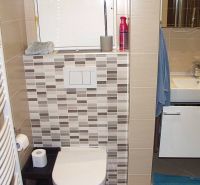 A bathroom in a 2-room apartment with a bathtub, sink, and tiles in neutral colors.