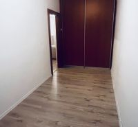 A hallway with a built-in wardrobe and a floor with a wood decor in a 3-room apartment.