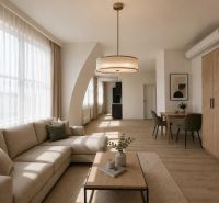 Living room with a sofa, table, and wooden decor flooring in a studio apartment.