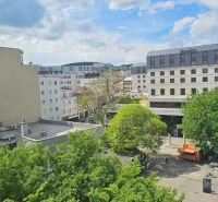 View of Poštová Street in Bratislava - Old Town with greenery and buildings.
