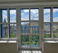 A view from a one-room apartment of the Bratislava skyline through large windows.