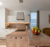 A kitchen with an island and fruit in a 2-room apartment, floor with a wooden decor.