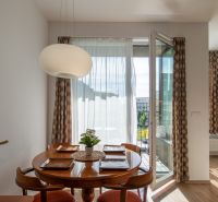 Dining area with a round table and chairs in a 2-room apartment.