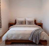 Bedroom with a bed and wooden furniture in a 2-room apartment, floor with wooden decor.