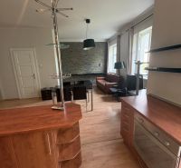 The kitchen of a 2-room apartment with a wooden decor floor and a modern counter.