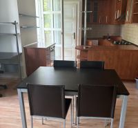 2-room apartment with a kitchen and dining area, wooden decor flooring, dark wood furniture.