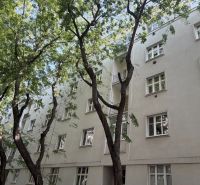 White apartment building on Dobrovského Street in Bratislava's Old Town, surrounded by greenery.