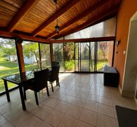 A glazed terrace in a family house with a view of the garden.