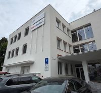 Office building on Dlhá Street in Prievidza with parked cars.
