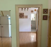 There is a wooden floor decor, a mirror, and decorations on the wall.