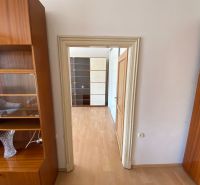 Interior of a 2-room apartment with a wooden decor floor and wooden furniture.