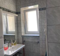 Bathroom in a 2-room apartment with tiles, a sink, and a window.