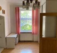 A room with a wooden floor decor and pink curtains in a two-room apartment.