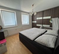 Bedroom in a 2-room apartment with a bed and a wardrobe, floor with wooden decor.