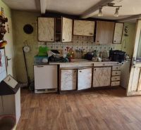 A kitchen space in a family house with a wooden decor floor and rustic decoration.