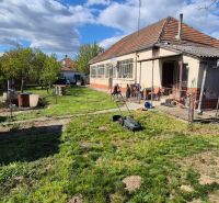 No Village: Family house with a garden and an annex, with a lawnmower on the lawn.