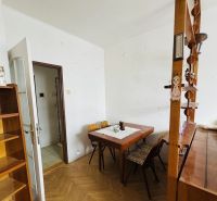 Dining room with a wooden table in a 3-room apartment, floor with wooden decor.