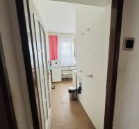 A narrow hallway leads to the kitchen in a 3-room apartment with red curtains.