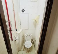 The interior with ceramic tiles includes a toilet with a ventilation opening and cleaning supplies.