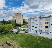 A view of residential buildings and a parking lot on Za poštou street in Hlohovec.