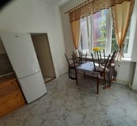 Kitchen in a 4-room apartment with large windows, a table, and a refrigerator.