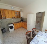 Kitchen in a 4-room apartment with a gas stove, refrigerator, and dining table.