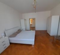 A bedroom in a 4-room apartment with light furniture and a wooden decor floor.