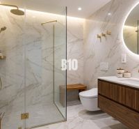 A bathroom with marble tiles, a shower corner, and a wooden washbasin cabinet in a family house.