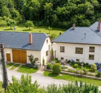 A family house in Belá-Dulice with a landscaped garden and surrounding greenery.