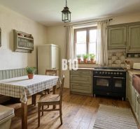A kitchen in a family house with retro furniture and a wooden decor floor.