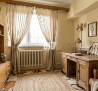 Interior of a family house with wooden furniture, carpet, and wall decorations.