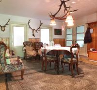 The interior of a family house with wooden paneling and hunting trophies on the walls.