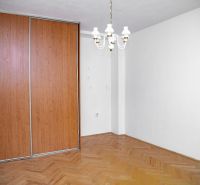 A room in a 2-room apartment with a wooden decor floor and a built-in wardrobe.