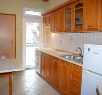A kitchen with wooden cabinets and a table in a 2-room apartment.