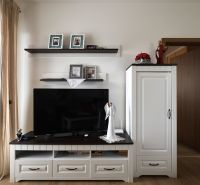 Living room in a two-room apartment with a TV on a cabinet and decorations.