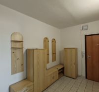 A hallway in a 2-room apartment with light furniture and tiled flooring.